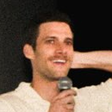 Taylor H. Jenisch on stage with a microphone, taking questions after a screening